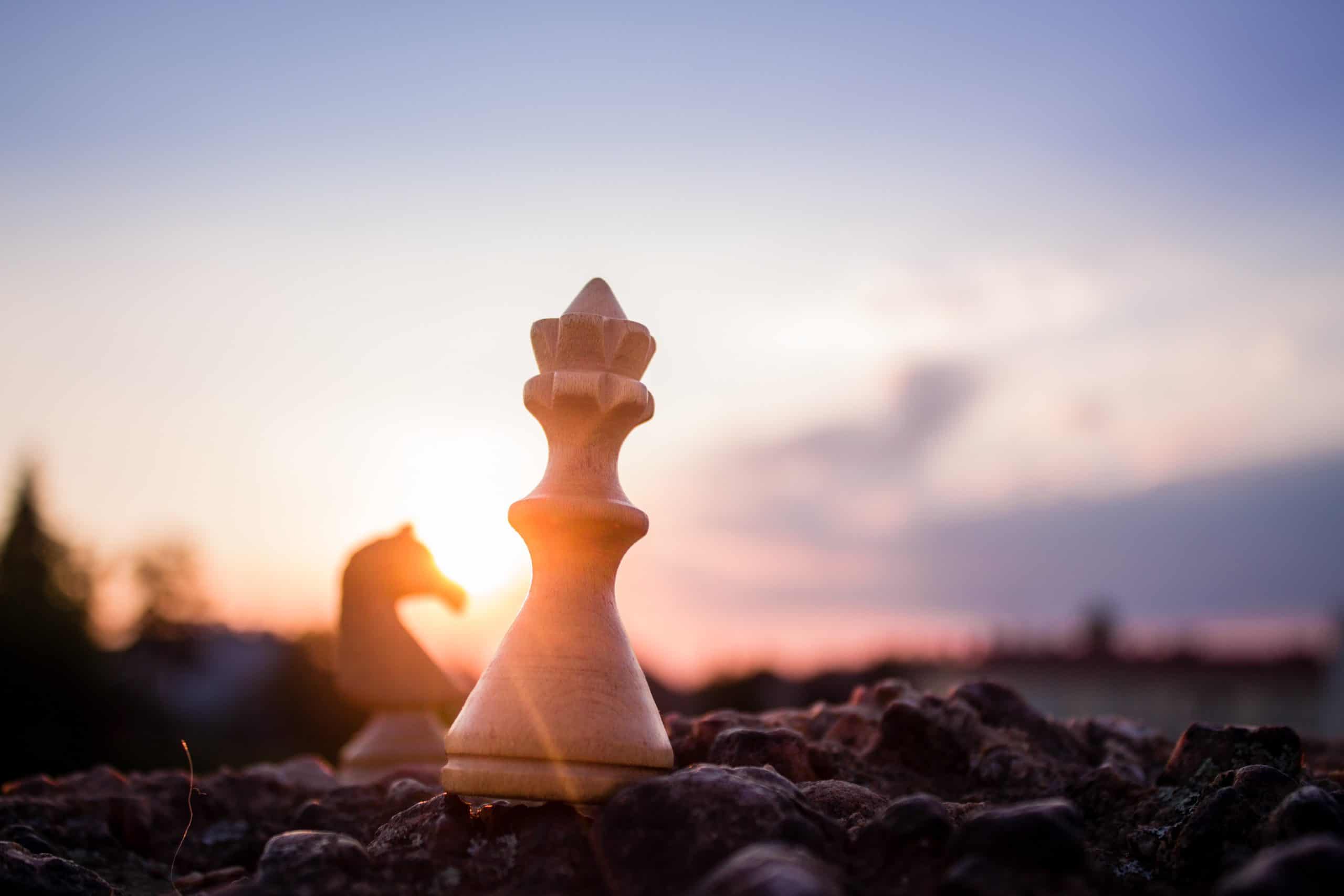 A chess piece sits on top of a rock at sunset A chess piece sits on top of a rock at sunset.