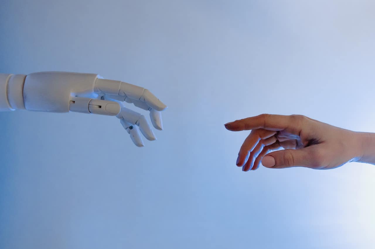 A robotic hand reaching out to a human hand A robotic hand reaching out to a human hand.